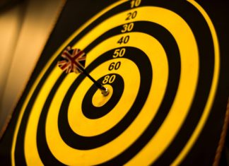 Bull's Eye with yellow dart in the center - Setting The Right Goals