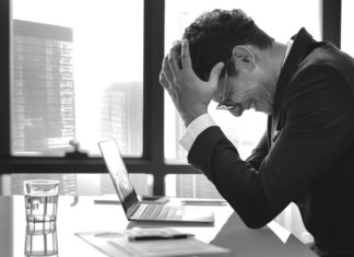 Top 5 Reasons Preventing You From Being More Successful frustrated man at his desk - Reasons Preventing You From Being More Successful